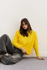 Sweater amarillo de punto con cuello redondo y mangas largas.