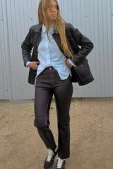 Pantalón de cuero marrón, de corte jeanero y piernas rectas.