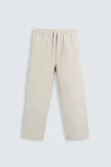 Pantalón de lino color beige, corte recto y relaxed fit, con cintura elástica ajustable con cordón, bolsillos laterales y traseros de parche.