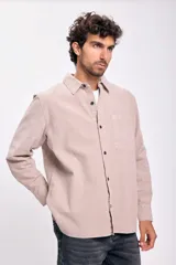 Camisa de manga larga color beige con botones negros.