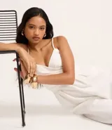 Mono blanco de pantalón ancho (pantalona) con escote cruzado en V y breteles finos ajustables.