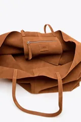 Bolso tipo maxi shopper color marrón de ante, con doble asa de hombro y bolsillo interior con cremallera.