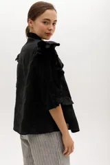 Chaleco celeste de lino con cuello mao, cierre frontal con botones y volados en hombros y bolsillos.