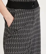Pantalón wide leg de malla crepé con estampado geométrico en blanco y negro, cintura alta con doble abotonadura.