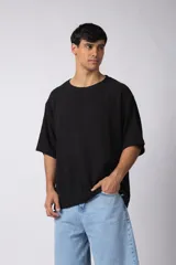 Remera negra de tejido tipo lino, corte holgado y cuello redondo. Sin estampas ni bordados.