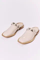 Sueco de cuero negro con detalle de apliques metálicos triangulares plateados.