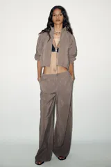 Pantalón palazzo color gris topo de tejido fluido, con cintura elástica ajustable con cordones y bolsillos laterales.