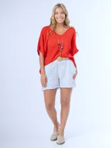 Remerón italiano confeccionado en bambula color naranja, con escote en V y calce oversized. Incluye collar largo con cuentas de colores y dije de estrella.