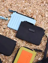 Billetera azul de poliuretano con cierre y correa de mano.