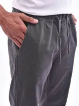 Pantalón jogger gris oscuro con cintura elástica ajustable con cordón y puños elásticos en los tobillos.