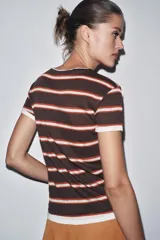 Camiseta gris con rayas horizontales negras, cuello redondo y mangas cortas.