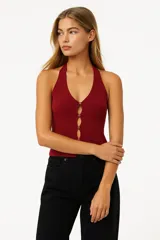 Top negro sin mangas de viscosa con cuello halter, abertura frontal con botones y corte ajustado.