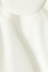 Remera color crudo de punto fino, con cuello redondo y mangas cortas.