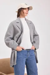 Tapado gris de lana con doble botonadura, cuello con solapas y bolsillos laterales.