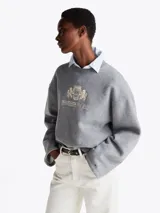 Buzo gris de Tommy Hilfiger de felpa con mezcla de algodón, cuello redondo, hombros caídos y manga ancha. Tiene cuello y bajo de punto canalé, logo bordado en el pecho y logo bordado en el ribete de la manga.