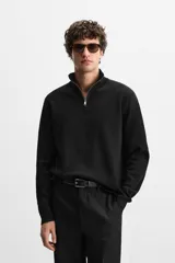 Jersey negro de punto de algodón, corte recto, cuello perkins con cremallera metálica y mangas largas terminadas en rib.