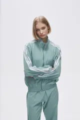 Campera deportiva verde con cierre frontal, cuello alto y tres rayas blancas en las mangas.