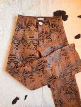 Pantalón de cuero negro, de corte recto y tiro alto, con bolsillos delanteros y traseros.