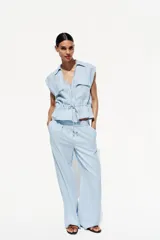 Pantalón celeste de tiro alto con cintura elástica, bolsillos delanteros y pernera ancha.