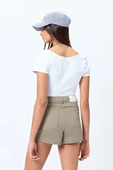 Short de jean color beige, con calce medio, bolsillos funcionales y tajos pequeños en el ruedo.