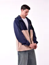 Campera con capucha azul marino y beige con cierre frontal y logo en el pecho.
