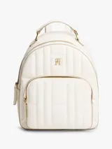 Mochila blanca acolchada con logo de Tommy Hilfiger en dorado. Tiene un asa superior, correas ajustables, cierre de cremallera, bolsillo interior con cremallera y bolsillo exterior con cremallera.