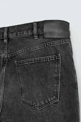 Pantalón de jean celeste, de tiro medio, corte ajustado en la parte superior y acampanado desde la rodilla. Tiene cinco bolsillos, efecto lavado y bajo irregular.