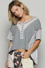 Remera corta color beige con diseño patchwork, escote redondo con botones y mangas cortas.