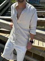 Camisa de lino color beige, con cuello mao y mangas largas. Cierre frontal con botones de madera.