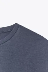 Camiseta azul de algodón con cuello redondo y mangas cortas caídas.