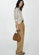 Sweater beige de cuello alto con cierre de cremallera, diseño oversize y mangas largas.