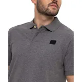 Remera tipo polo color petróleo con cuello de punto acanalado, puños de manga de punto plano y parche de silicona con el logo de Cat en el lado izquierdo del pecho.