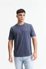 Remera azul de corte clásico, cuello redondo y logo bordado en el pecho.