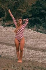 Enterito de lycra Ecocean reciclada con protección SPF 50, con mangas largas y cierre frontal. Estampa estilo 60s en el cuerpo y mangas rosadas con estampado de cactus.