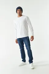 Jean azul oscuro de corte recto, con tiro medio, roturas en la pierna y logo bordado en el bolsillo trasero.