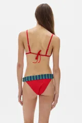 Conjunto de bikini rojo con rayas verticales azules y verdes. El corpiño es de corte triangular con breteles finos y abertura en el centro. La bombacha es de corte clásico con cintura ancha.