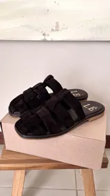 Sandalias bajas color rosa viejo con tiras de cuero entrelazadas y suela marrón.