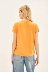 Remera color naranja de algodón peruano, con escote en V y mangas cortas.