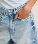 Pantalón baggy de jeans celeste con trabillas en la cintura, cierre tradicional y bolsillos. Corte holgado y de tiro alto.