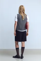 Top gris de cuello alto y sin mangas.