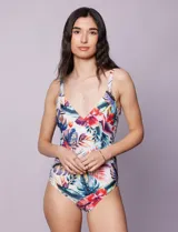 Malla enteriza estampada con motivos florales y hojas en tonos azules, rojos, amarillos y verdes. Escote en V cruzado y breteles regulables.