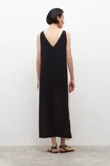 Vestido midi de lino color beige con laterales blancos, escote en V y cinturón negro con hebilla redonda.