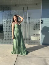 Vestido largo color verde con tirantes finos, escote en V y falda con volantes.