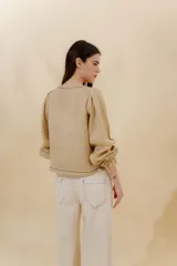 Blusa color beige de lino 100% con mangas balloon y detalle de tablón en el hombro. Tiene mangas largas con detalle de 2 pespuntes elásticos en contratono, el recurso del elástico es ideal para remangarse la manga generar más volumen. Calce recto, largo por arriba de la cadera.