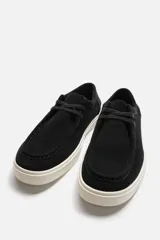 Zapato casual de cordones color negro, con capellada de cuero serraje, detalle de bordón en el empeine y suela de goma color crema.