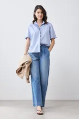Camisa celeste de manga corta con cuello y ruedo con volados.