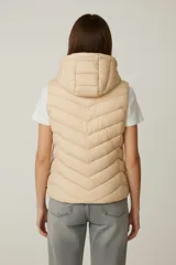 Chaleco acolchado negro con costuras horizontales, cierre frontal y capucha fija.