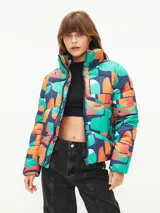 Campera puffer corta con estampado abstracto en tonos verde, naranja y azul. Tiene cuello alto, cierre frontal con cremallera y bolsillos laterales.