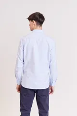 Camisa celeste de corte slim fit, con cuello clásico y mangas largas.