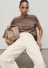 Pantalón de jean tiro alto, color blanco crudo, corte culotte con bajo deshilachado.